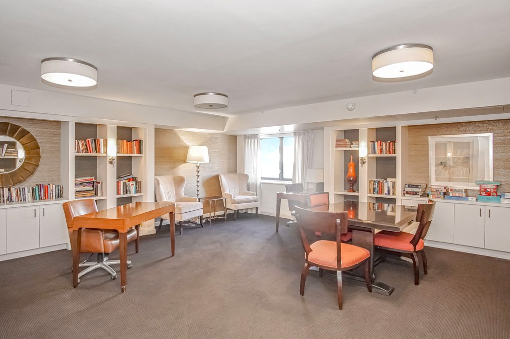 a club house with a table and chairs and a library at 10 West Apartments, Long Beach, New York