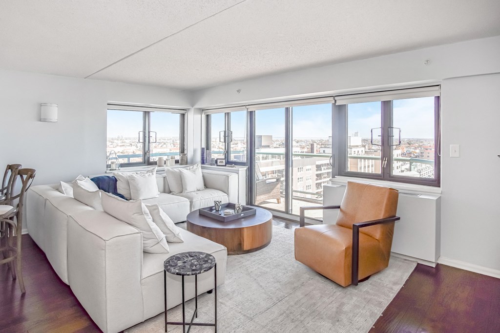 a living room with white couches and a coffee table at 10 West Apartments, Long Beach, NY, 11561
