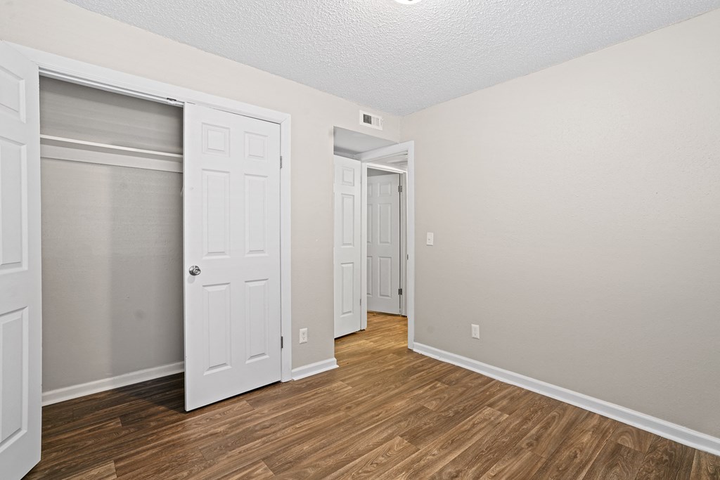 a bedroom with a door to a closet and a hard wood floor at Diamond  Trail Apartments, Oklahoma, 73112