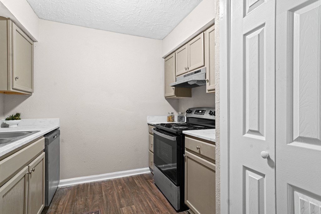 the kitchen of our studio apartment atrium with black appliances and white cabinets at Diamond  Trail Apartments, Oklahoma City, Oklahoma