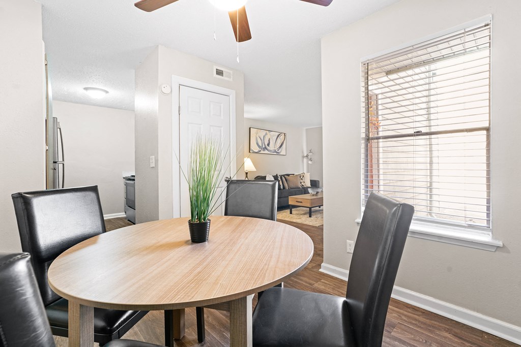 a dining room with a wooden table and black leather chairs a dining room with a wooden table and black leather chairs at Diamond Trail Apartments, Oklahoma