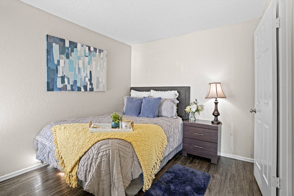 bedroom with yellow blanket on bed and blue pillows