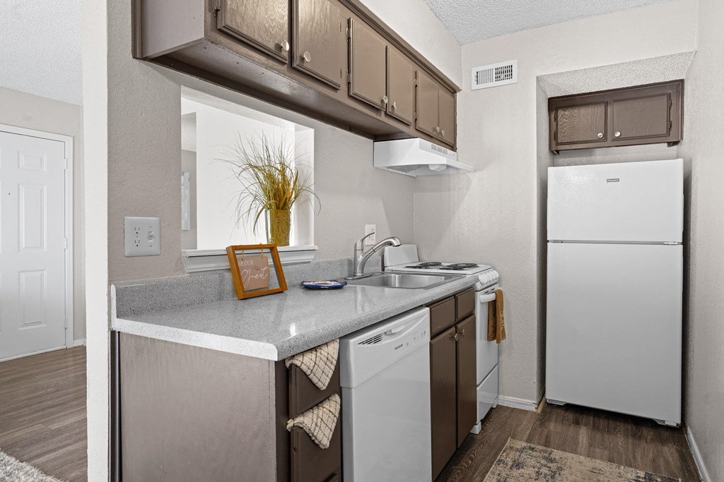 kitchen area with white refrigerator and brown cabinets