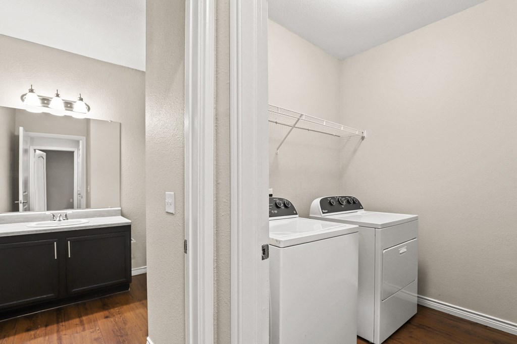 a bathroom with a washer and dryer and a sink