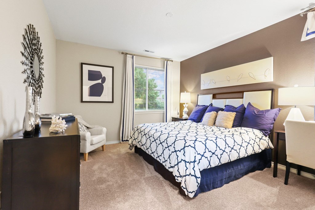 a bedroom with a large bed and a desk with a chair