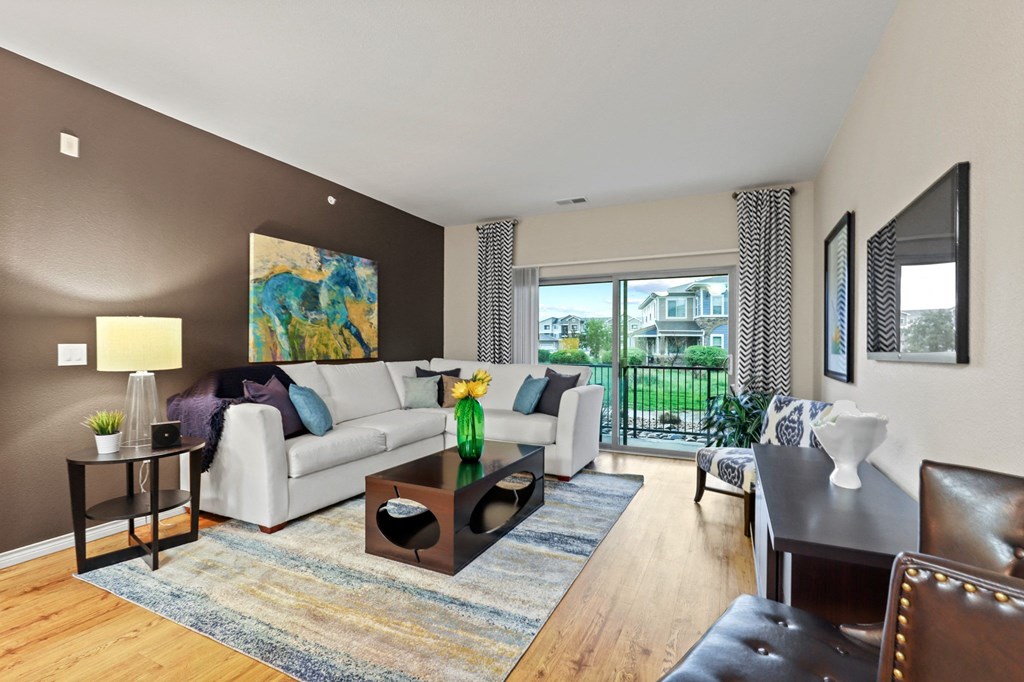 a living room with brown walls and a sliding glass door leading to a balcony