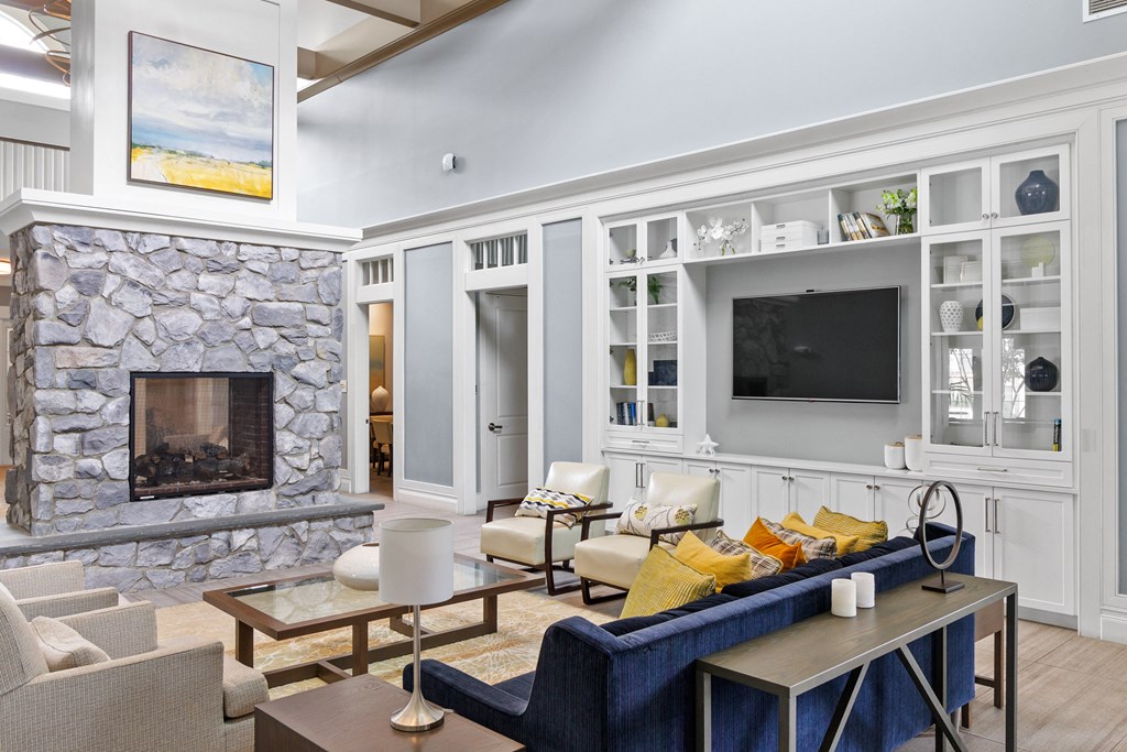 a living room filled with furniture and a large stone fireplace at Cirrus Apartments, Ashland, 01721