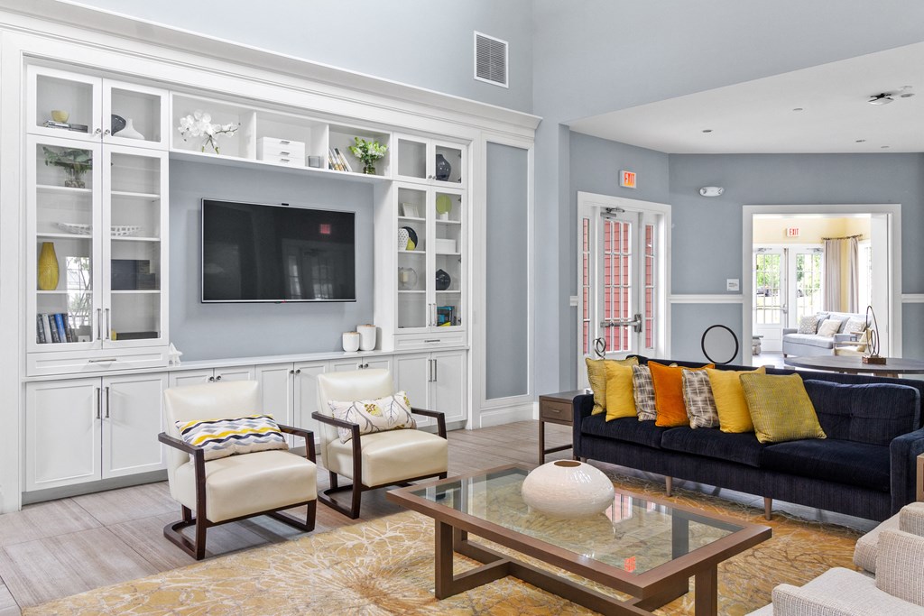 a living room with a black couch and yellow pillows at Cirrus Apartments, Ashland, Massachusetts