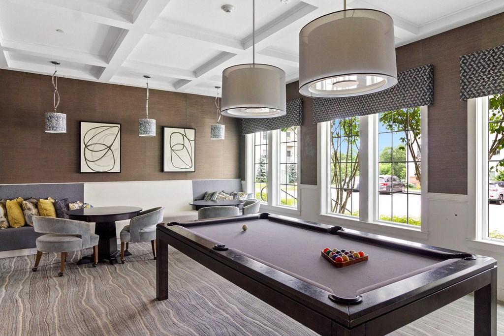 a recreation room with a pool table and chairs at Cirrus Apartments, Ashland, MA