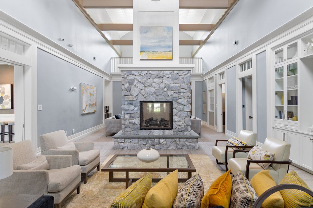 a living room filled with furniture and a large stone fireplace at Cirrus Apartments, Ashland, MA