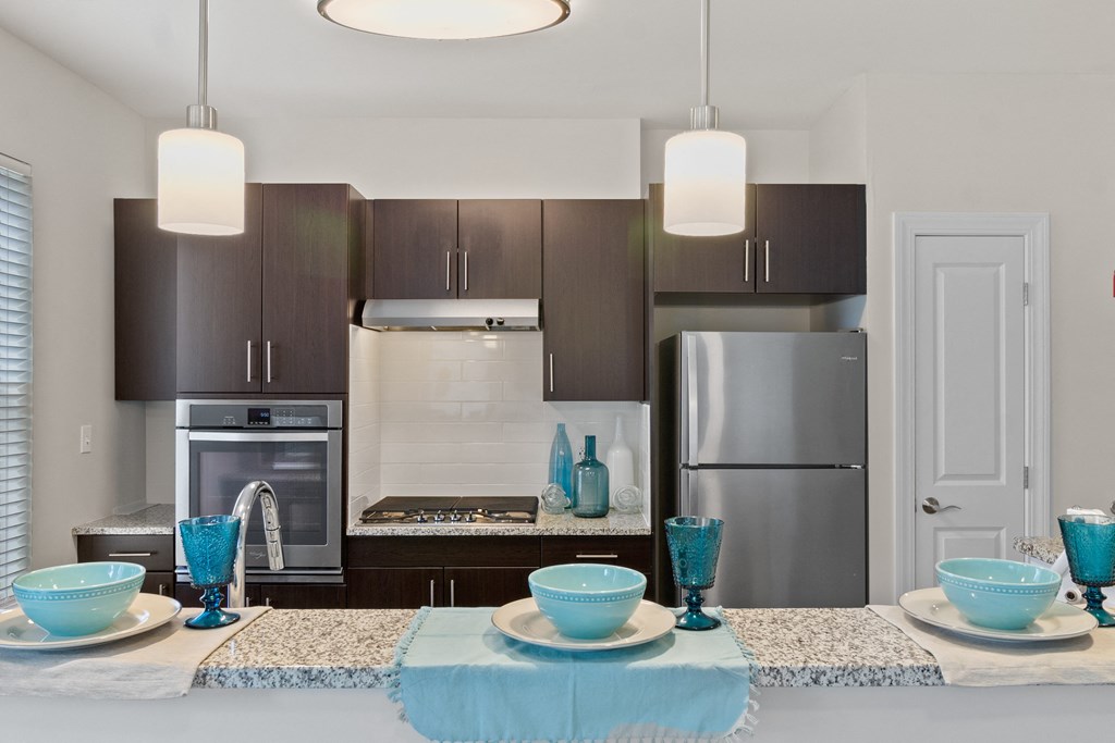 a kitchen with a large island and stainless steel appliances at Cirrus Apartments, Massachusetts, 01721