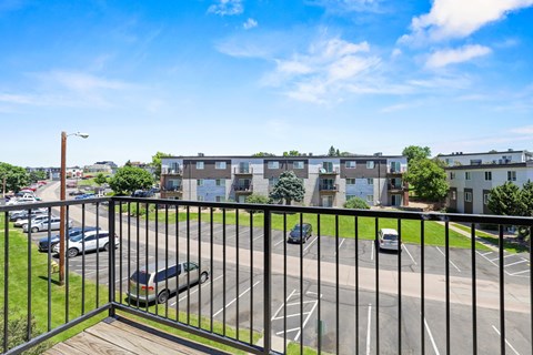 a balcony with a black railing overlooking a parking lot at Park 88 Apartments, Colorado