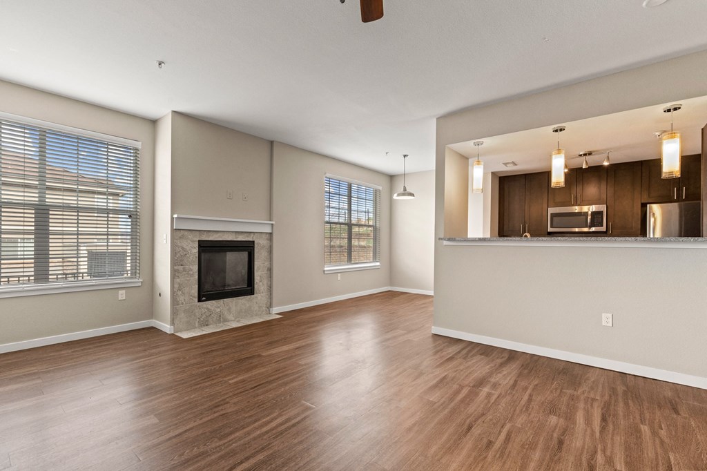 a living room with a fireplace and a kitchen  at Black Feather Apartment Homes, Castle Rock, CO