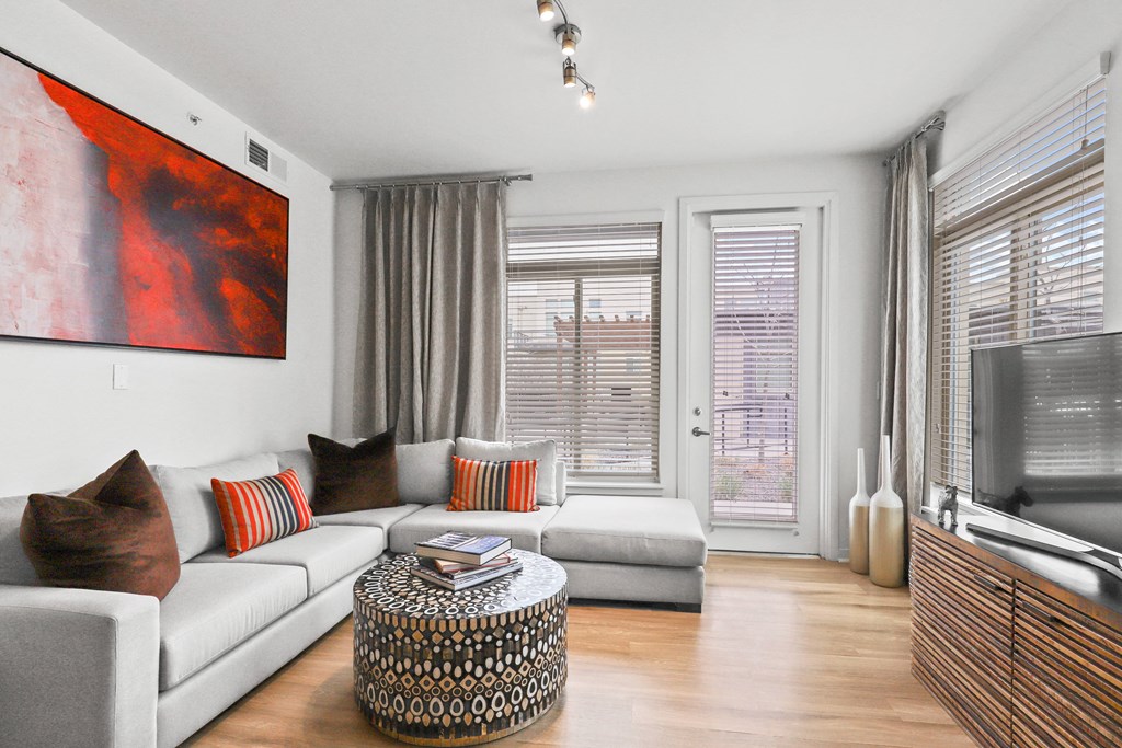 a living room with a white couch and a large red painting on the wall