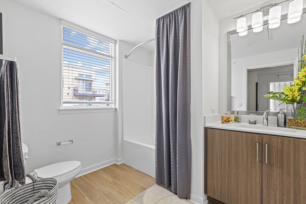 a bathroom with a toilet sink and bathtub in a 555 waverly unit