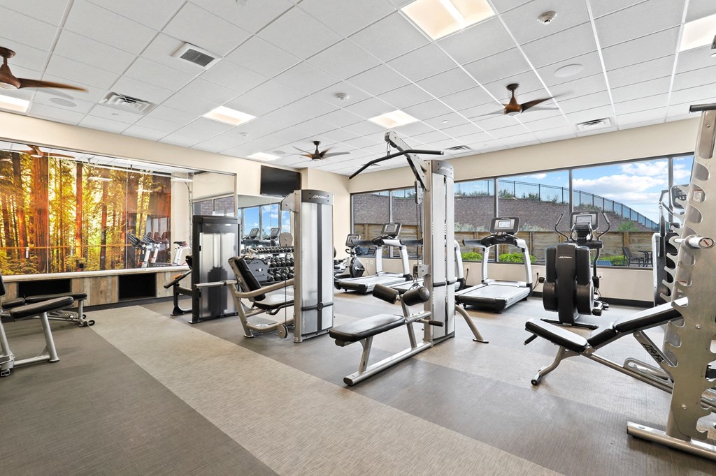 a large fitness room with treadmills and other exercise equipment at Union West Apartments, Colorado
