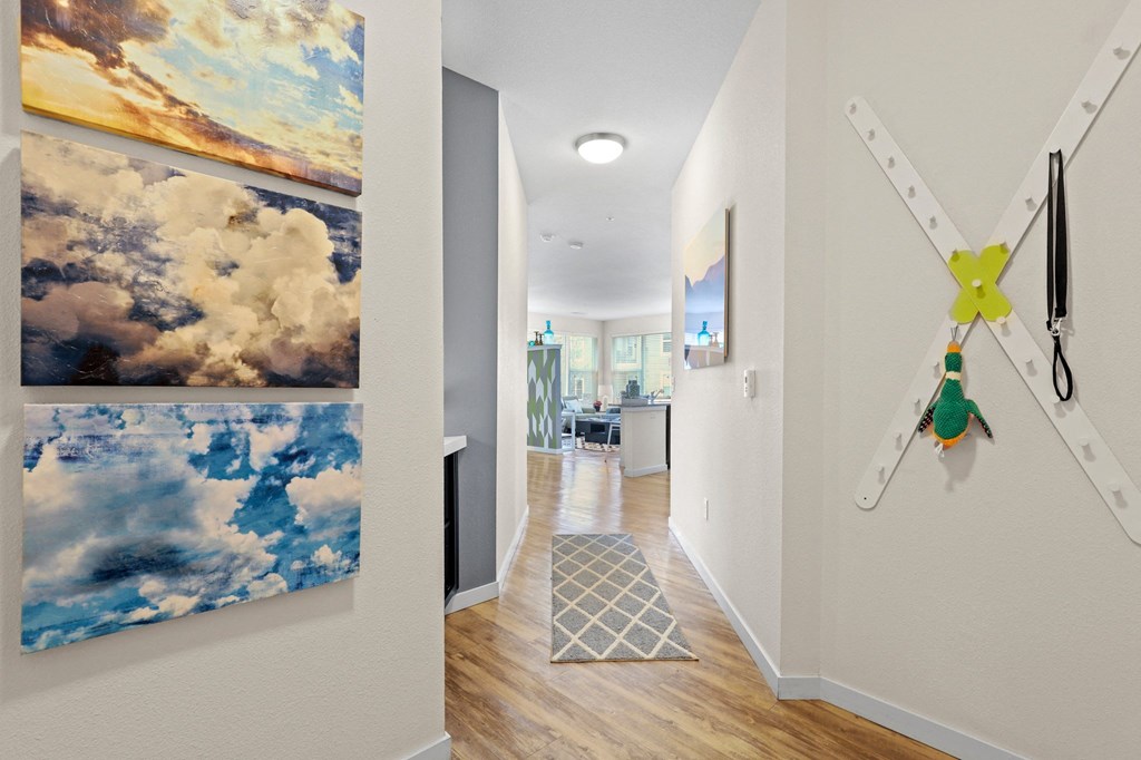 a hallway with paintings and a clock on the wall