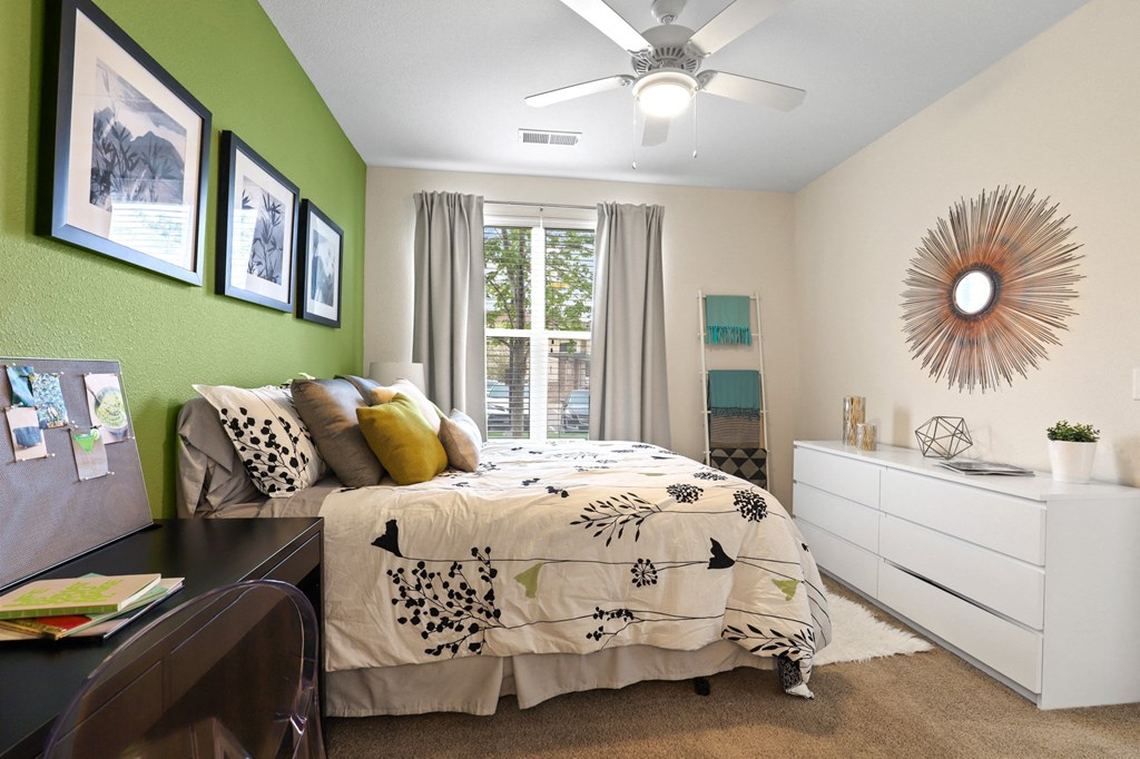 a bedroom with a large bed and green accent wall