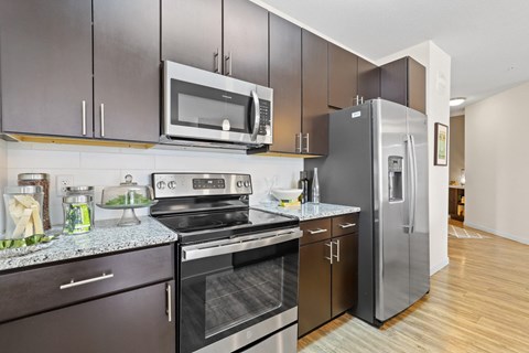 a modern kitchen with stainless steel appliances and a stainless steel refrigerator at WestLink at Oak Station, Colorado, 80215