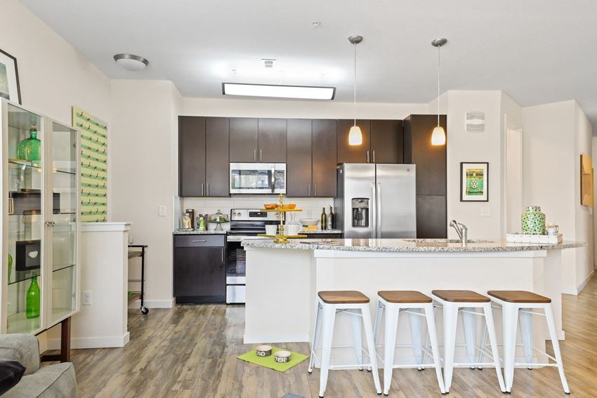 a kitchen with a large island with three stools in front of it