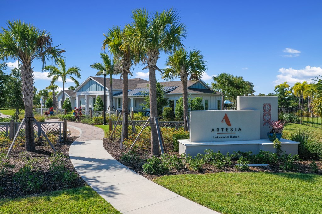 a sidewalk leading to a sign in front of a house with palm trees at Artesia at Lakewood Ranch Apartments, Bradenton, FL, 34211