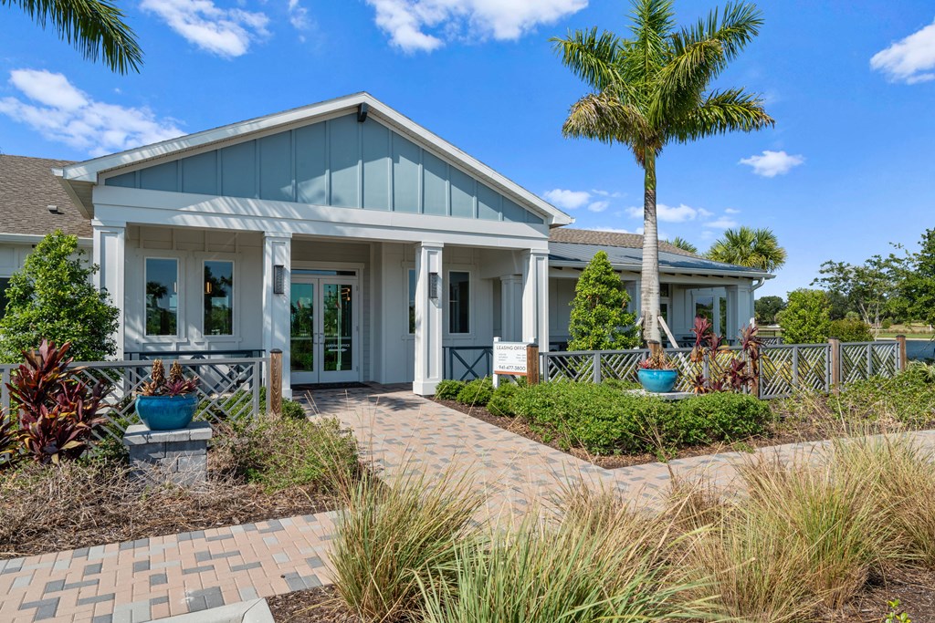 a house with a porch and a palm tree in front of it at Artesia at Lakewood Ranch Apartments, Bradenton, Florida