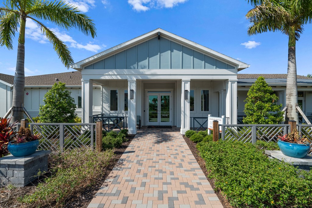 the front of a house with a walkway and palm trees at Artesia at Lakewood Ranch Apartments, Bradenton, FL