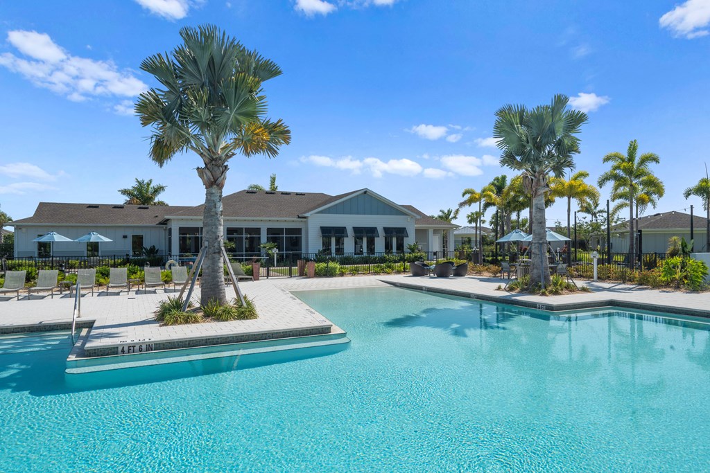 a large swimming pool with palm trees in front of a house at Artesia at Lakewood Ranch Apartments, Bradenton, FL, 34211