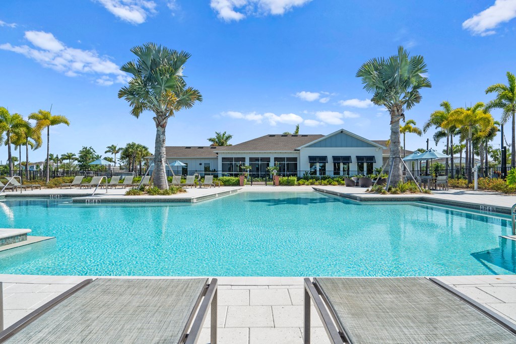 a large pool with palm trees and a building in the background at Artesia at Lakewood Ranch Apartments, Bradenton, FL