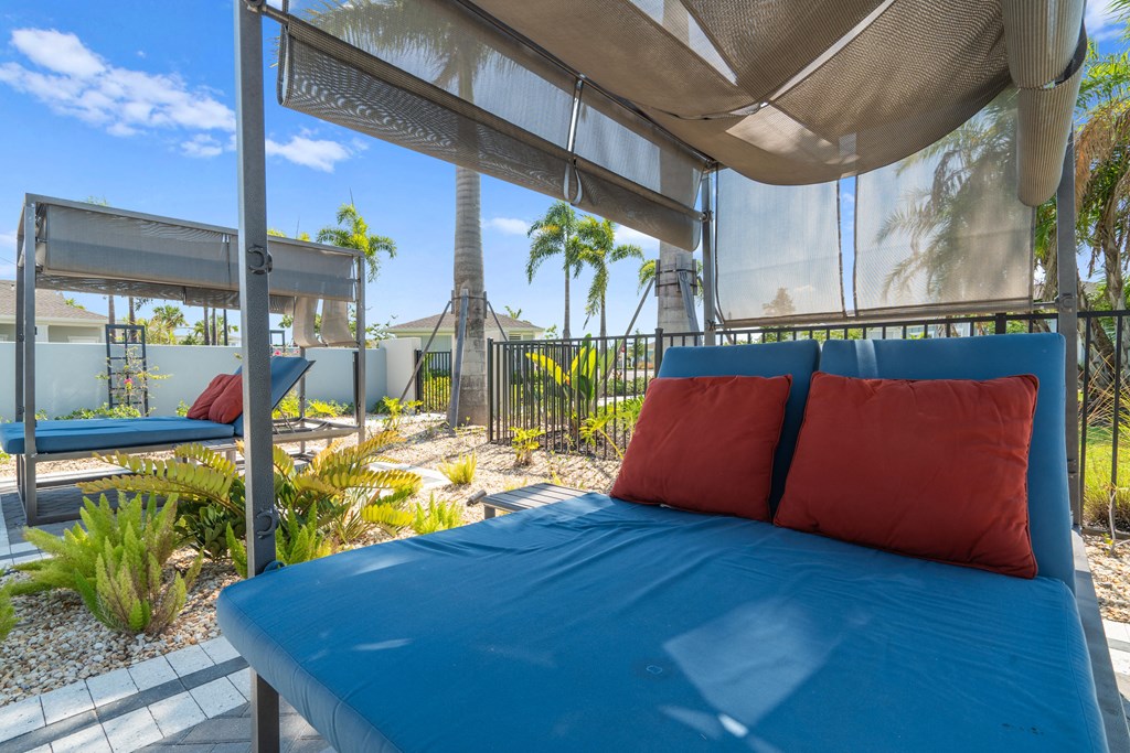 a patio with a blue bed and red pillows at Artesia at Lakewood Ranch Apartments, Florida