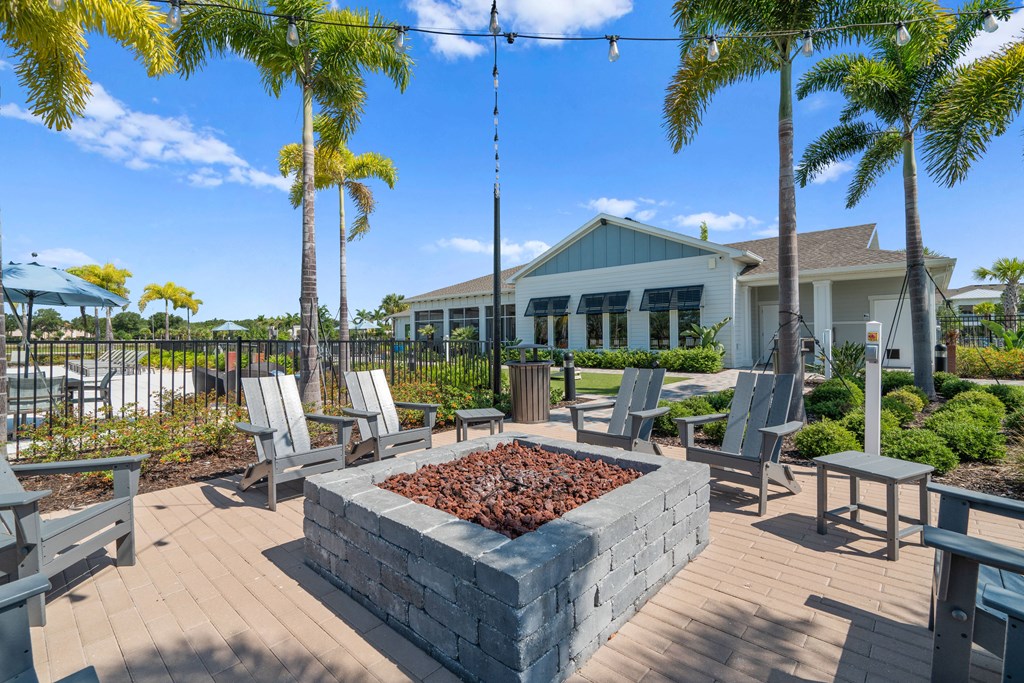 a patio with chairs and a fire pit and a building in the background at Artesia at Lakewood Ranch Apartments, Bradenton