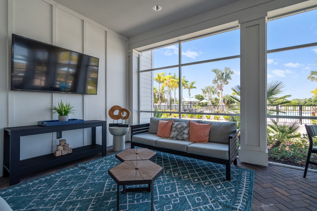a living room with a couch and a television and a balcony at Artesia at Lakewood Ranch Apartments, Bradenton, FL, 34211