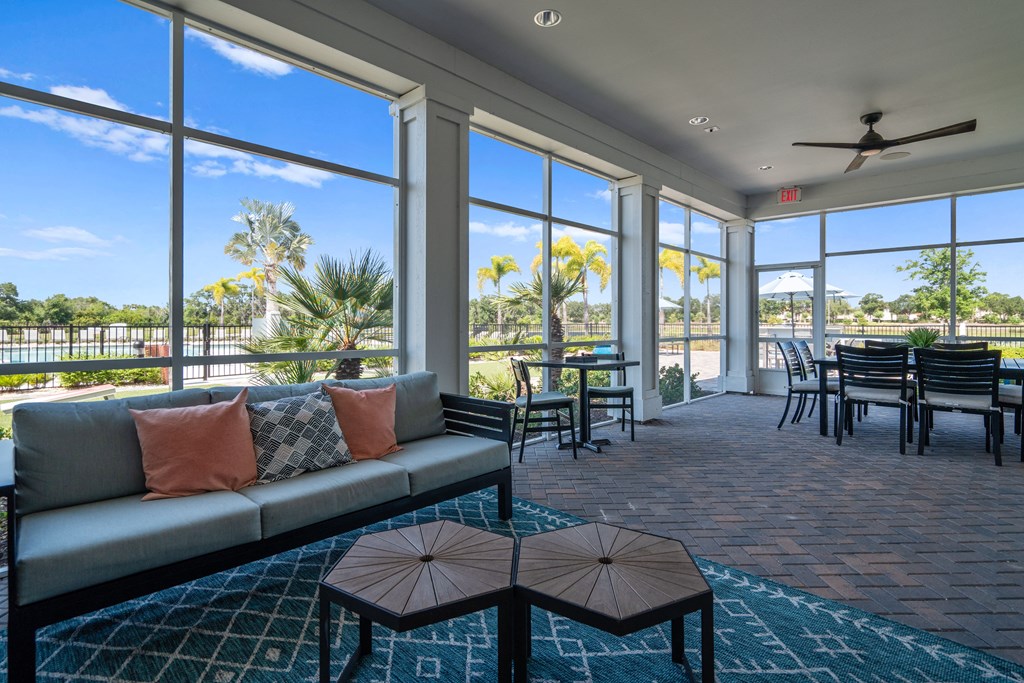 a living room with a couch and a table with chairs and windows at Artesia at Lakewood Ranch Apartments, Bradenton, 34211