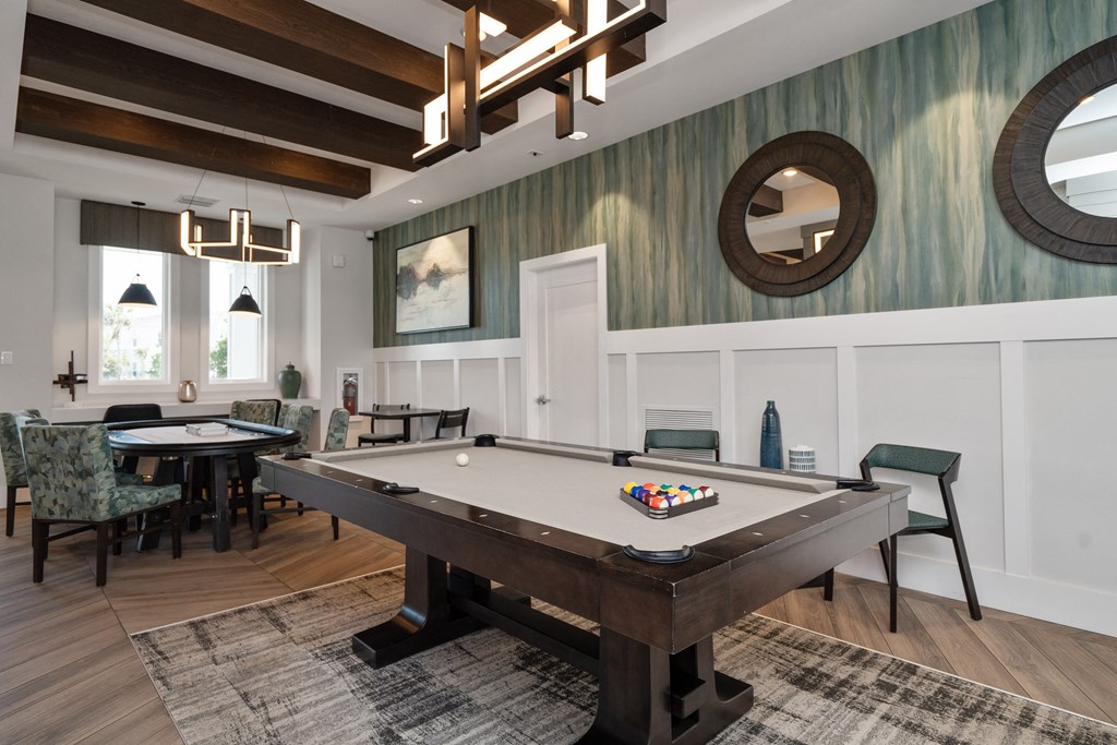 a billiards table in a clubhouse with tables and chairs at Artesia at Lakewood Ranch Apartments, Bradenton, FL, 34211