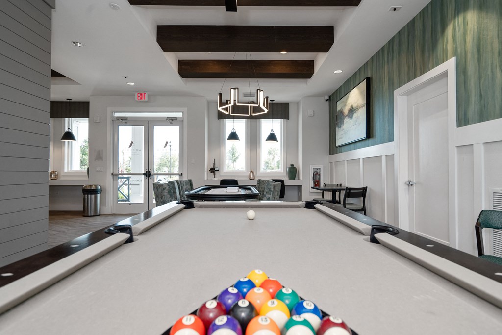 a pool table in a living room with a bunch of balls on it at Artesia at Lakewood Ranch Apartments, Bradenton, Florida