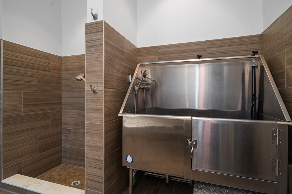 a large stainless steel tub in a bathroom with wooden walls and a shower at Artesia at Lakewood Ranch Apartments, Bradenton, FL