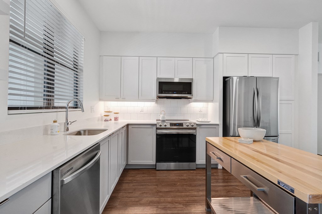 a kitchen with white cabinets and stainless steel appliances and a wooden counter top a kitchen with white cabinets and stainless steel appliances and a wooden counter top at Odyssey, Fort Myers, FL, 33905