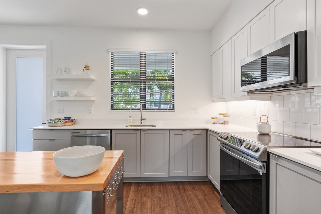 a kitchen with stainless steel appliances and a wooden table at Odyssey, Florida, 33905