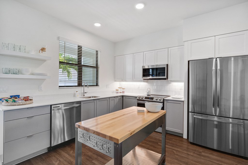 a kitchen with stainless steel appliances and a wooden table at Odyssey, Fort Myers