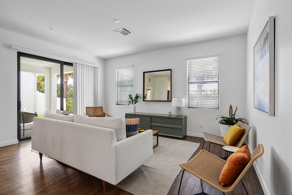 a living room with a couch and chairs and a sliding glass door at Odyssey, Florida, 33905