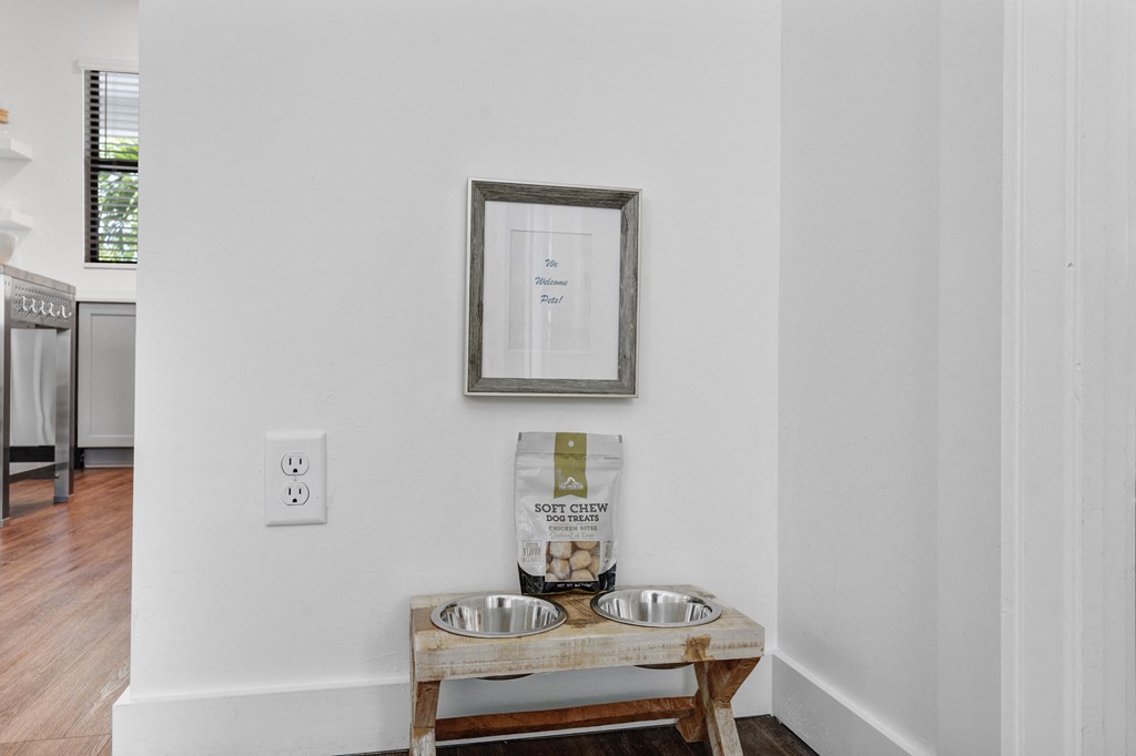 a small kitchen with two stainless steel bowls and a wooden table with a wooden stool at Odyssey, Florida