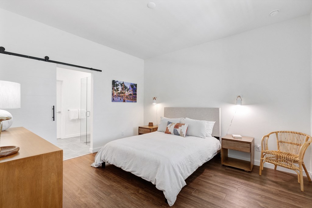 a bedroom with a bed and a dresser and a door to a bathroom at Odyssey, Fort Myers, FL, 33905