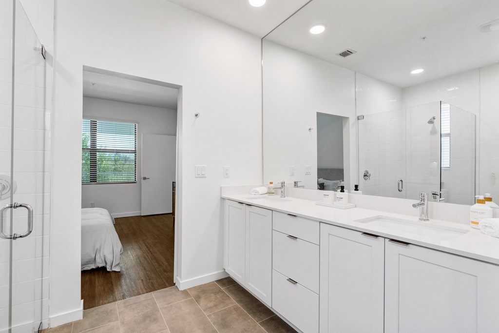 a white bathroom with two sinks and a mirror at Odyssey, Fort Myers, Florida
