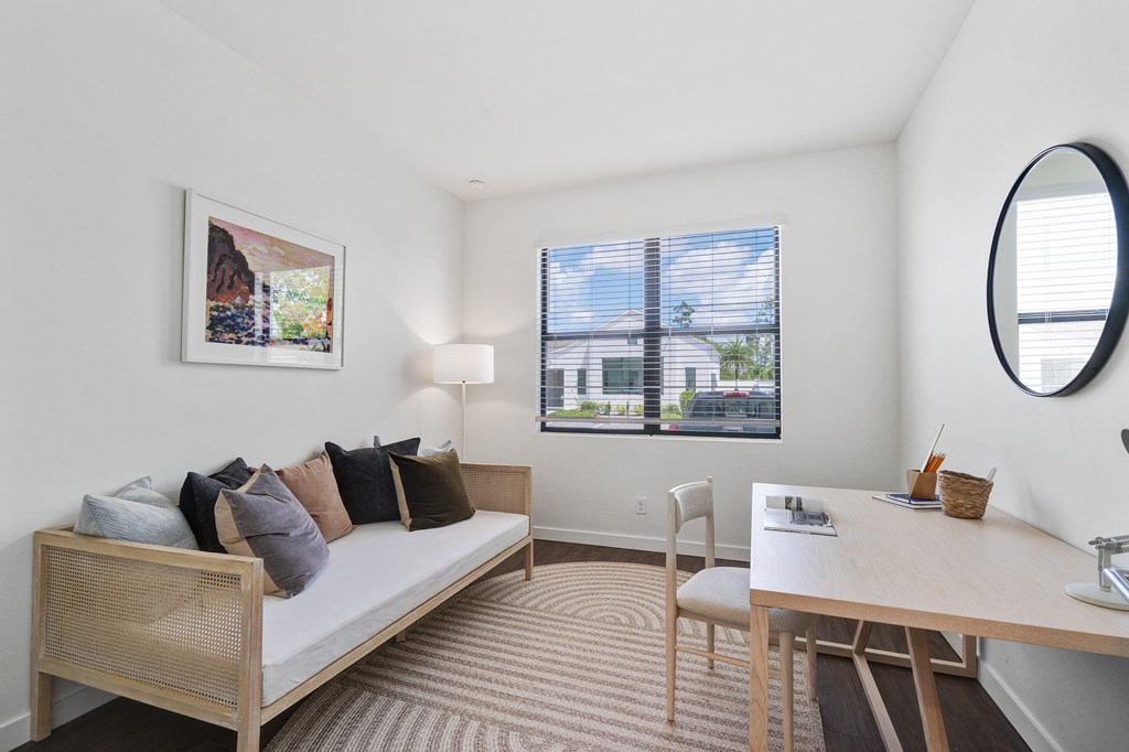 a living room with a couch and a desk and a window at Odyssey, Florida