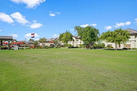 a large lawn with houses in the background at Soleil at Canyon Trails Apartments, Arizona