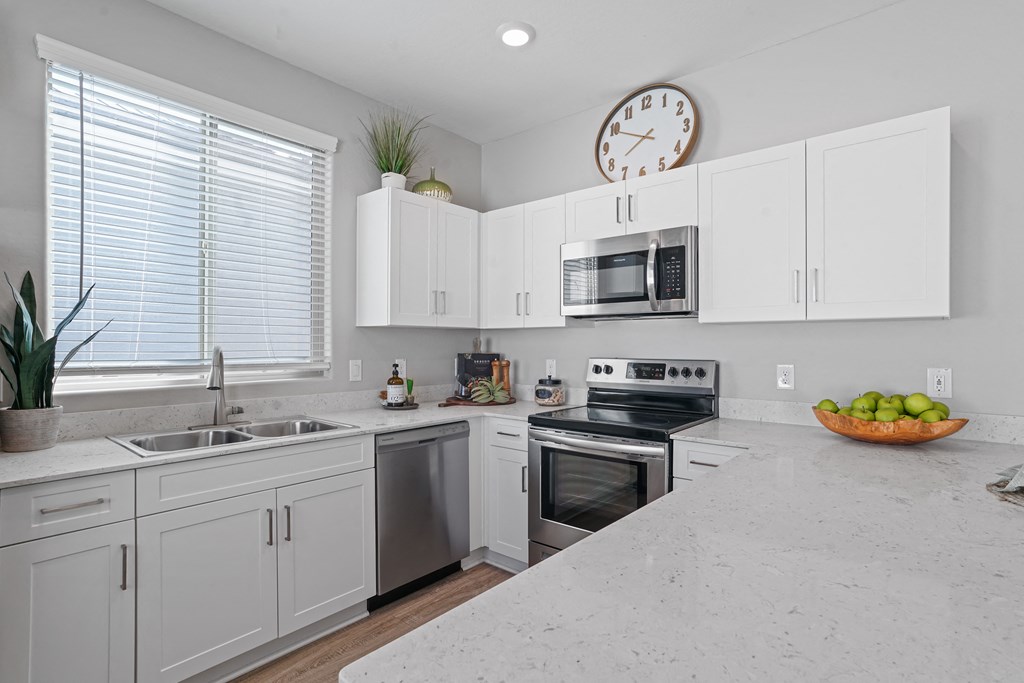 a large kitchen with white cabinets and a counter top at Sienna at South Mountain Apartments, Arizona