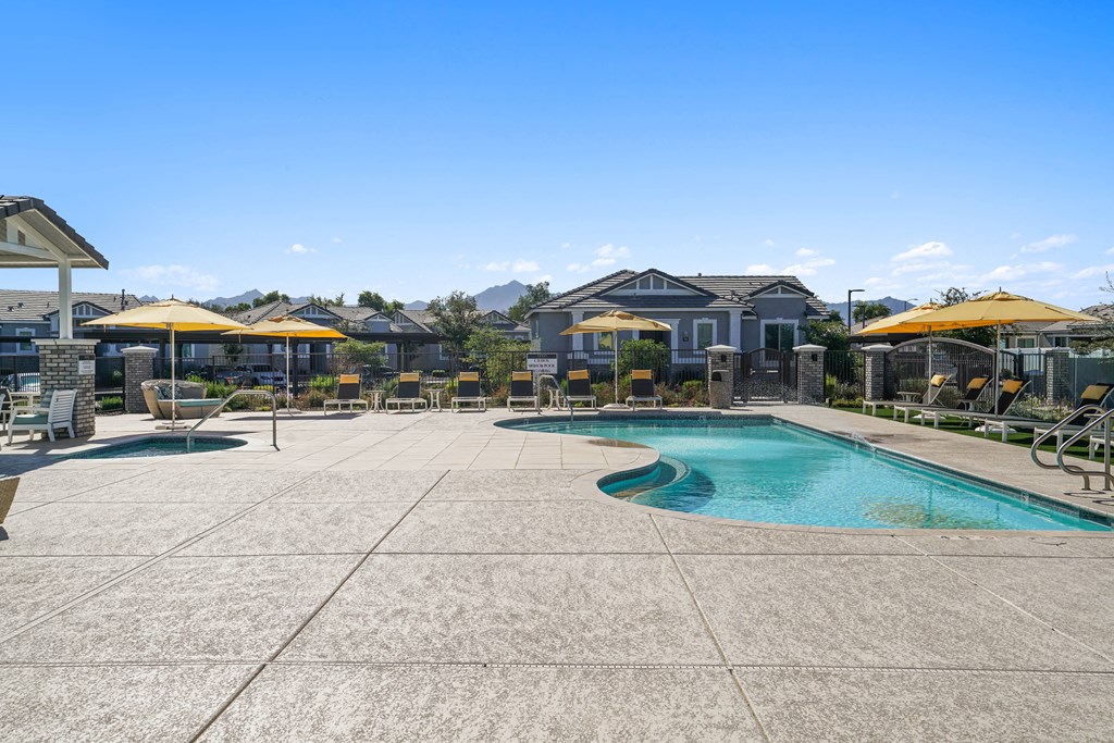 a swimming pool with patio furniture and umbrellas next to a resort style pool at Sienna at South Mountain Apartments, Laveen, 85339