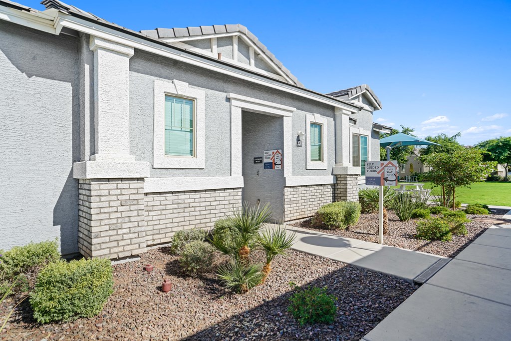 a white brick house with a sidewalk in front of it at Sienna at South Mountain Apartments, Laveen, AZ