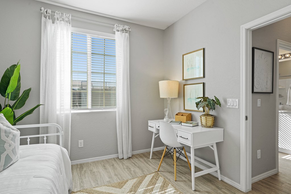 a bedroom with a bed and a desk and a window at Sienna at South Mountain Apartments, Laveen, Arizona