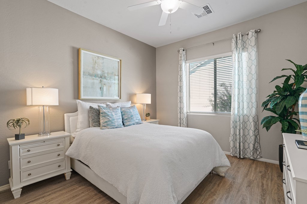 a bedroom with a bed and a window at Sienna at South Mountain Apartments, Laveen, AZ